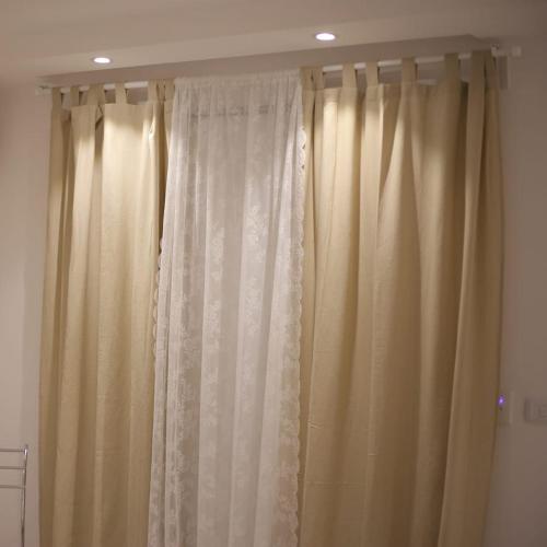 a white curtain in a room with a ceiling at Apartment in Mohandesin (Families Only) in Cairo