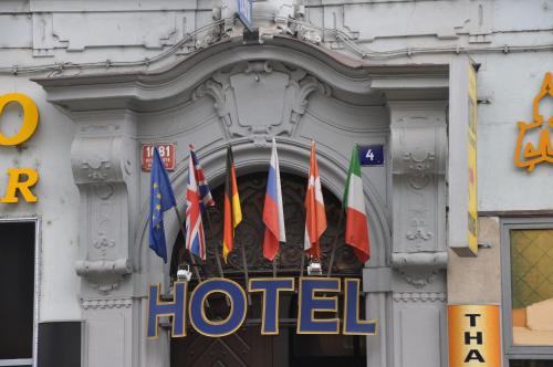 a group of different flags in front of a hotel at City Centre in Prague