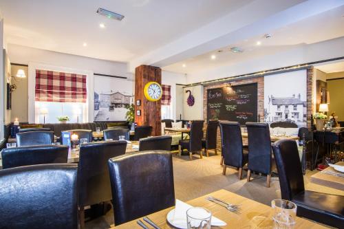 a restaurant with tables and chairs and a clock at Grantham Arms in Boroughbridge