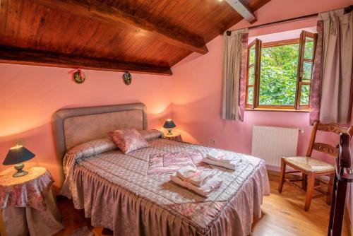 1 dormitorio con 1 cama con paredes de color rosa en Casa de Aldea el Ferreirón en Castropol