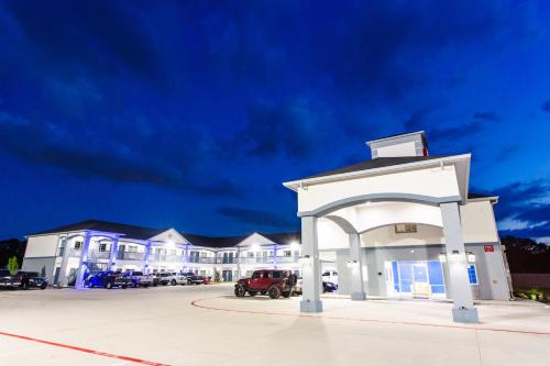 a large white building with a red truck in front at Palace Inn- Louetta in Spring