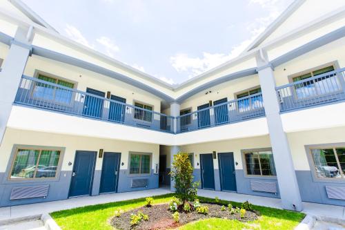a large white building with blue doors and a courtyard at Palace Inn- Louetta in Spring
