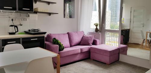 - un salon avec un canapé violet et une table dans l'établissement DELUXE PAŃSKA APARTMENTS, à Varsovie