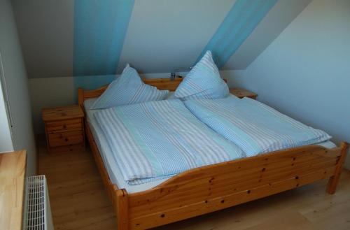 a bedroom with a wooden bed with blue walls at Ferienwohnung Wiekenblick in Wiesmoor