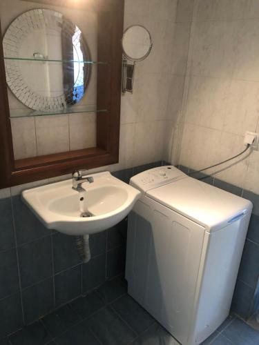 a bathroom with a sink and a washing machine at Anna House Palouri in Paliouri