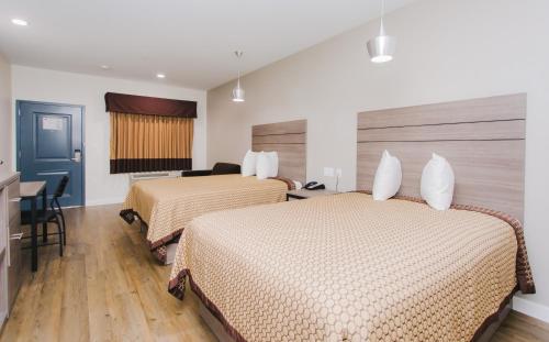 a hotel room with two beds and a desk at Palace Inn- Louetta in Spring