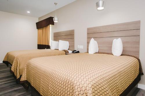 two beds in a hotel room with two beds at Palace Inn- Louetta in Spring