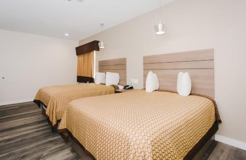 two beds in a hotel room with two beds at Palace Inn- Louetta in Spring