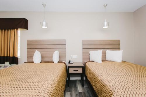 two beds in a hotel room with two beds at Palace Inn- Louetta in Spring