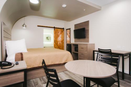 a hotel room with a bed and a table and chairs at Palace Inn- Louetta in Spring