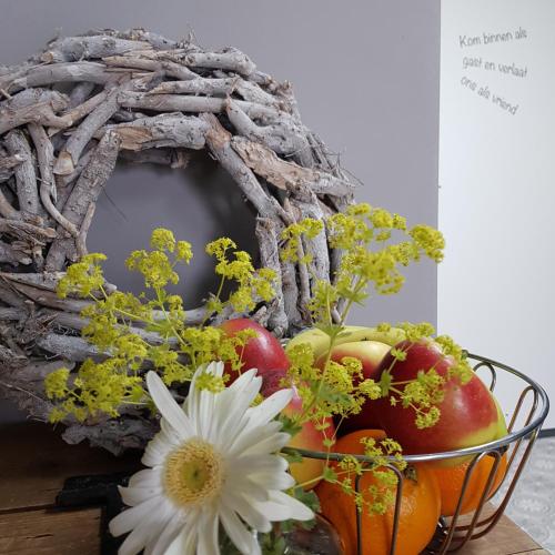 a basket of fruit and flowers on a table at Op de Bult in Rasquert