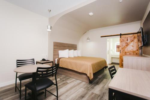 a hotel room with a bed and a table and chairs at Palace Inn- Louetta in Spring