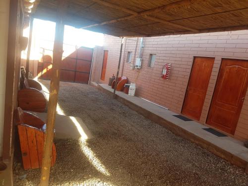 a room with a building with a barn with wooden doors at Hostal Nuevo Sol y Viento in San Pedro de Atacama