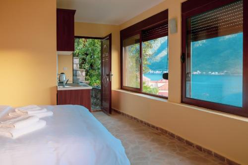 a bedroom with a bed and a view of the water at Villa & Apartments Perasto in Perast