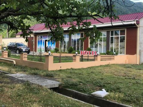 a bird sitting in the grass in front of a house at Alp Hotel in Qax
