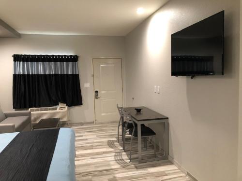 Zimmer mit einem Bett und einem Schreibtisch mit einem TV in der Unterkunft Crystal Inn Downtown in Houston