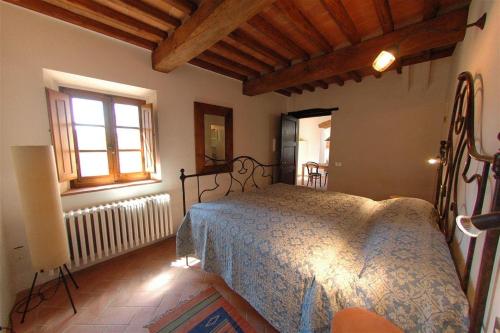 um quarto com uma cama e uma janela em Bellini em Gaiole in Chianti