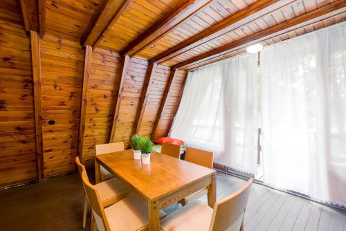 ein Esszimmer mit einem Holztisch und Stühlen in der Unterkunft Domki jak PRLu w Camp LIPNO in Stęszew