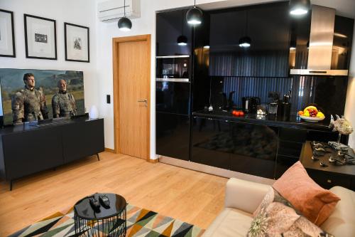a living room with a couch and a kitchen at Apartamento Mar II WITH PARKINg in Sesimbra