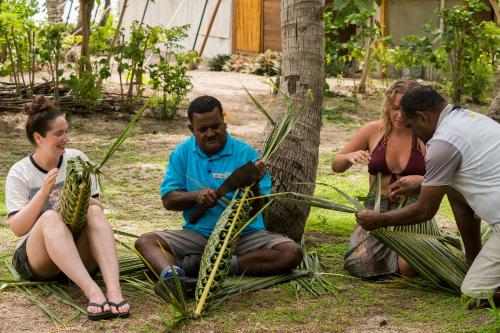 a group of people sitting next to a tree at Barefoot Manta Island Resort in Drawaqa Island