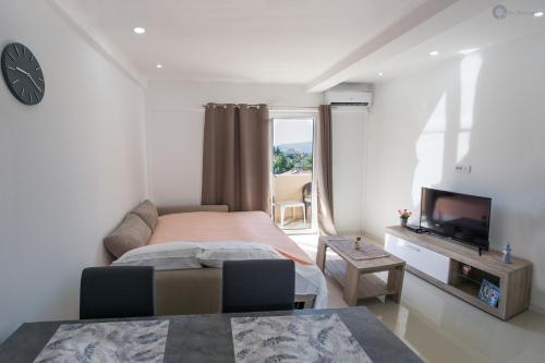 a bedroom with a large bed and a tv at Apartmani Kankaras - Sea View in Tivat