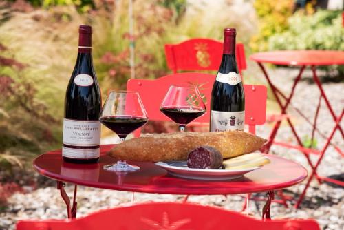 Deux bouteilles de vin et une assiette de nourriture sur une table dans l'établissement Gite 1er Cru - La Loubertine, à Saint-Loup-Géanges