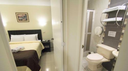 a small bathroom with a bed and a toilet at Casa Fanning Hotel in Lima