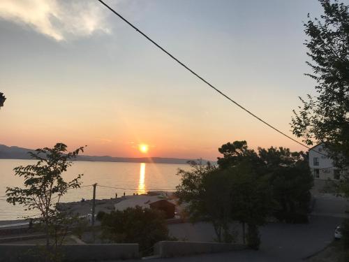 a sunset over a body of water at Apartman Nadia in Karlobag