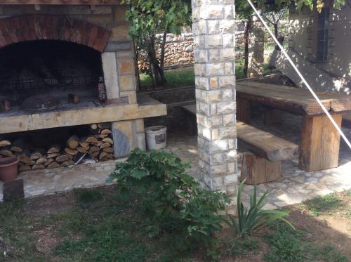 a stone oven with a fire place in a yard at Apartman Nadia in Karlobag