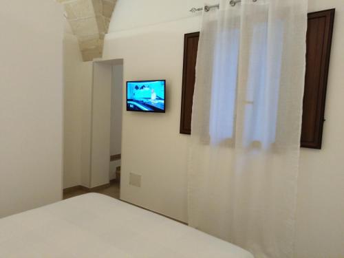 een kamer met een bed en een televisie aan de muur bij la casetta in Favignana