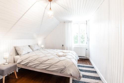 biała sypialnia z łóżkiem i oknem w obiekcie LA VILLA JEAN-BART w mieście Saint-Valéry-sur-Somme