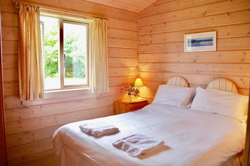 a bedroom with a bed in a log cabin at Lapwing, Skylark & Curlew Seaside Chalets in Kirkbean