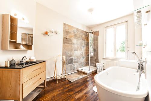 a bathroom with a tub and a sink and a toilet at LA VILLA JEAN-BART in Saint-Valéry-sur-Somme