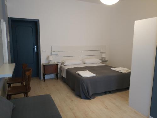 1 Schlafzimmer mit 2 Betten, einem Tisch und einer Tür in der Unterkunft B&B Via Nazionale in Milazzo