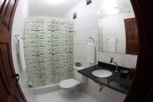 a bathroom with a sink and a toilet and a shower at Vila Pura Vida in Canoa Quebrada
