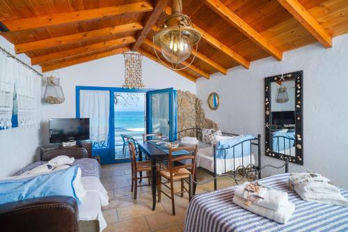 a room with two beds and a dining room with a table at Agyrovoli Bungalow in Skala Kallirachis