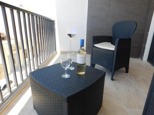 a bottle of wine and two glasses on a table at Paradise in Għajnsielem