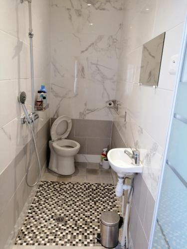 une salle de bain avec toilettes et lavabo dans l'établissement Chambres d'Hôtes Chez Marilou, à Aulnay-sous-Bois