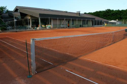 a tennis court with a net in front of a building at Tennis- und Freizeitzentrum Neudörfl in Neudörfl