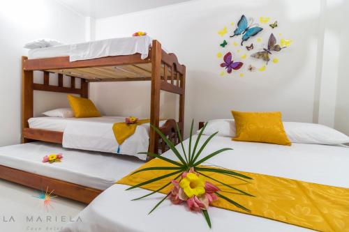 2 literas en una habitación con mariposas en la pared en Casa Hotel La Mariela en Zapzurro