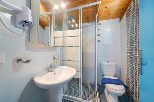 a bathroom with a toilet and a sink and a shower at Agyrovoli Bungalow in Skala Kallirachis