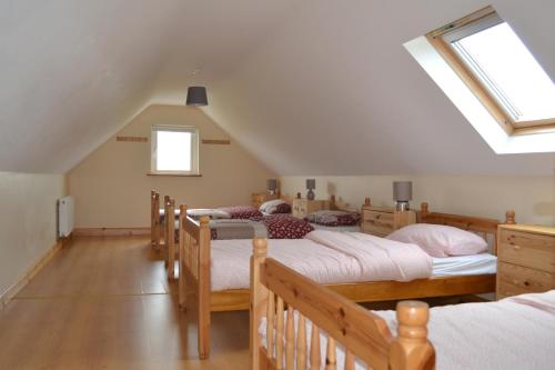 een slaapkamer met 4 bedden op een zolder bij Sally's Vineyard in Buncrana