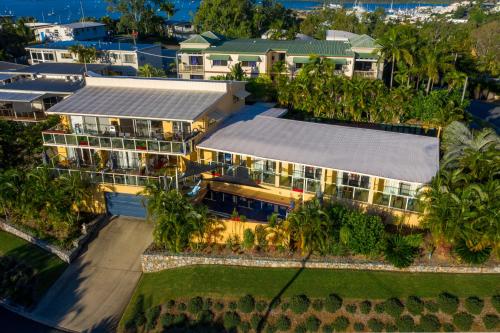 une vue aérienne d'une maison avec des palmiers dans l'établissement Sunlit Waters Studio Apartments, à Airlie Beach
