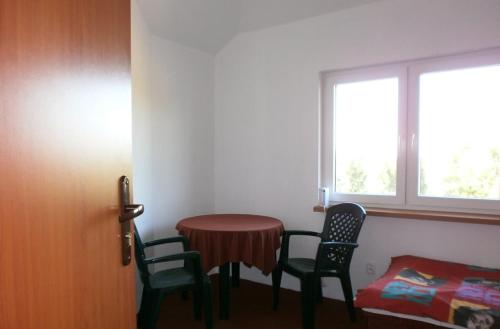 a room with a table and two chairs and a window at Dom Żaglowiec in Olsztyn