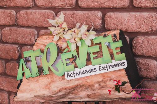 a sign on a brick wall with flowers on it at Hotel San Jorge in Tlatlauquitepec