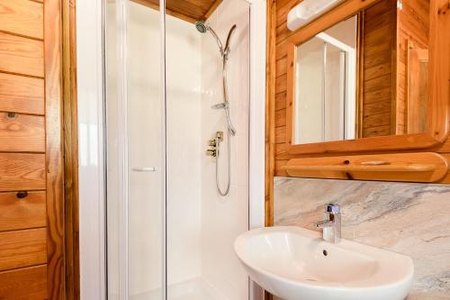 a bathroom with a sink and a shower at Woodlands Hotel & Pine Lodges in Grange Over Sands