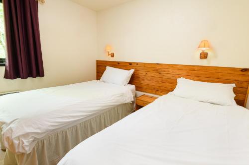 two beds sitting next to each other in a room at Woodlands Hotel & Pine Lodges in Grange Over Sands