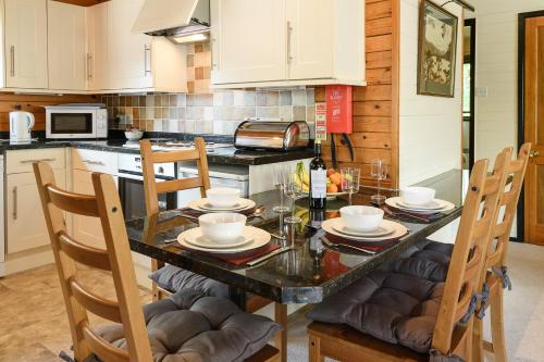a kitchen with a dining room table with chairs and a counter at Woodlands Hotel & Pine Lodges in Grange Over Sands