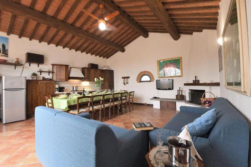 a living room with blue couches and a kitchen at Casale Vecchio Fienile in SantʼAppiano