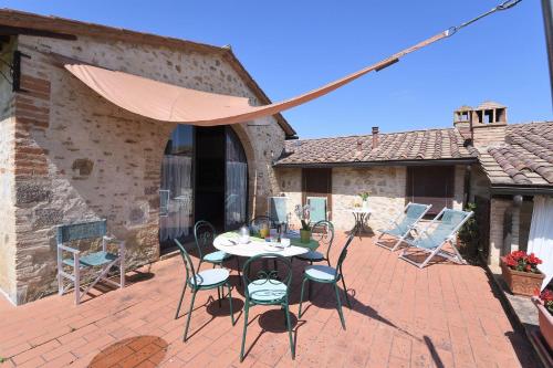 a patio with a table and chairs and an umbrella at Casale Vecchio Fienile in SantʼAppiano